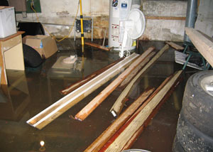 A severely flooding basement in Gresham, with lumber and personal items floating in a foot of water