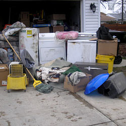 Soaked, wet personal items sitting in a driveway, including a washer and dryer in Hillsboro.