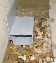 A no-clog basement french drain system installed in Springfield