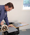 installing a waterproof vapor barrier on a basement floor to prepare for basement carpeting in a Eugene home