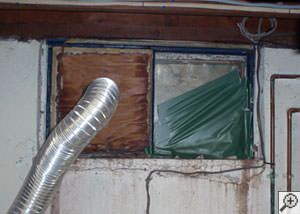 A basement window system that's rotted and  has been damaged over time in Woodburn.