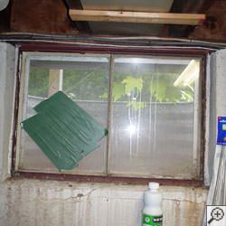 An old, rusted basement window with a steel frame in Hillsboro.