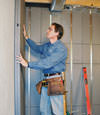 Insulated basement wall panels being placed against a concrete foundation wall in Springfield